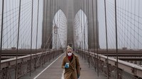 Seorang warga melintas di jembatan Brooklyn yang sepi akibat wabah Covid 19. Getty Images/Victor J. Blue.