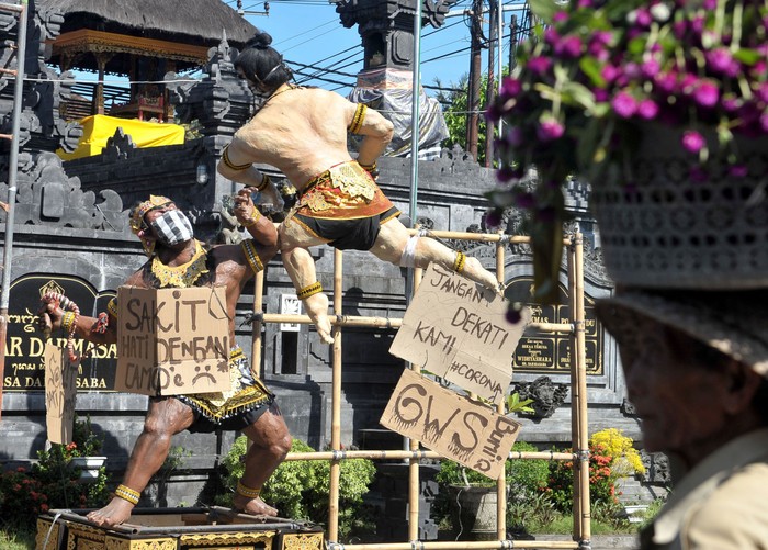 LARANGAN ARAK-ARAKAN OGOH-OGOH Warga melintas di dekat Ogoh-ogoh yang dibuat menjelang Hari Raya Nyepi Tahun Saka 1942 di Badung, Bali, Minggu (22/3/2020). Gubernur Bali Wayan Koster menginstruksikan larangan pelaksanaan pengarakan Ogoh-ogoh dalam bentuk apapun yang berpotensi menimbulkan keramaian dan kerumuman orang di seluruh wilayah Bali sebagai upaya pencegahan penyebaran COVID-19. ANTARA FOTO/Fikri Yusuf/foc.