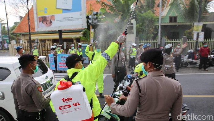 polisi semprot pengguna jalan dengan disinfektan