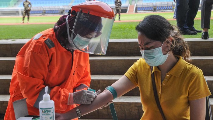 Petugas medis mengecek kesehatannya dengan mengambil sampel  darah dengan metode rapid test (pemeriksaan cepat) di Stadion Patriot Candrabhaga, Bekasi, Jawa Barat, Rabu (25/3/2020). Pemeriksaan yang dilakukan khusus tenaga medis di Bekasi guna memutus mata rantai penyebaran virus COVID-19. ANTARA FOTO/ Fakhri Hermansyah/hp.
