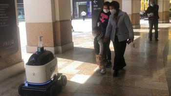 Robot ini juga membagikan hand sanitizer kepada warga yang melintas. AP Photo.