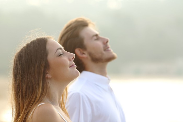 ilustrasi berjemur sinar matahari pagi Profile of a couple of man and woman breathing deep fresh air together at sunset