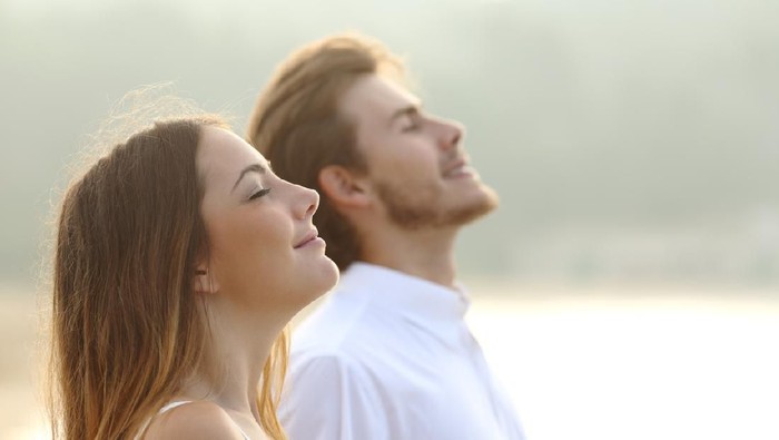 ilustrasi berjemur sinar matahari pagi Profile of a couple of man and woman breathing deep fresh air together at sunset
