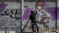Seorang anggota dari kelompok pegiat grafiti RBS CREW di Senegal membuat sebuah mural terkait cara pencegahan penyebaran virus Corona. AP Photo/Sylvain Cherkaoui.