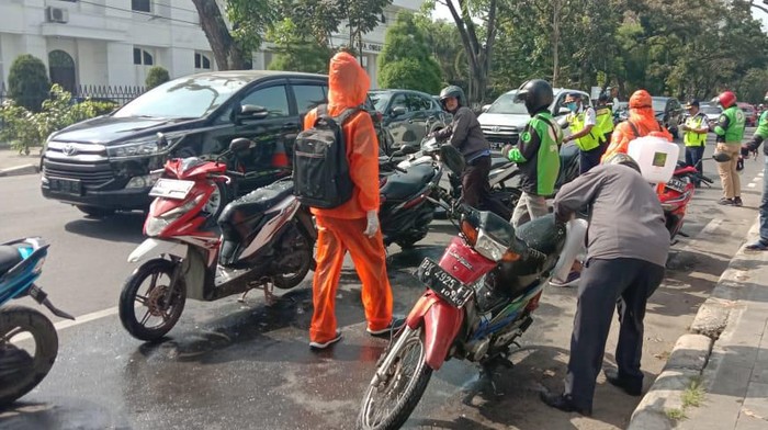 Penyemprotan disinfektan ke motor ojol hingga betor. (Foto: Ahmad Arfah/detikcom)