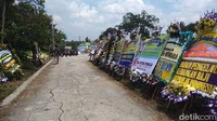 Karangan bunga duka cita membanjiri area makam keluarga tersebut.