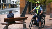 Seorang polisi menegur warga yang berada di area publik pada hari pertama lockdown, di ibukota Wellington, Selandia Baru (26/3/2020). Photo by Hagen Hopkins/Getty Images