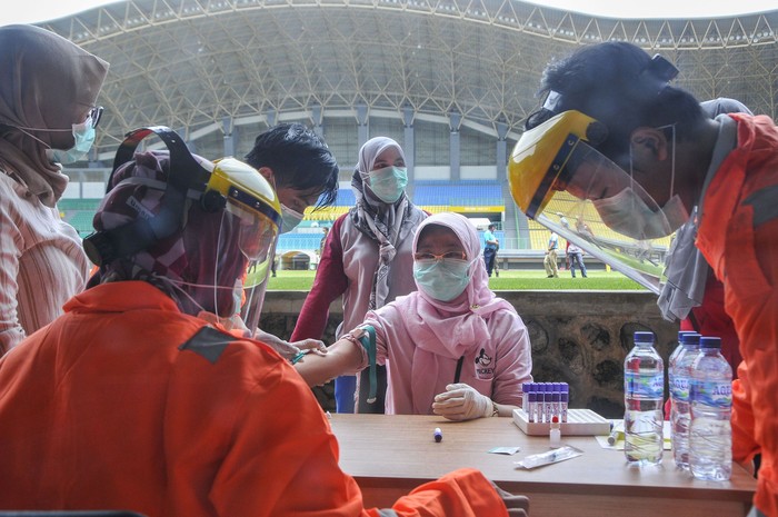 Petugas medis mengecek kesehatannya dengan mengambil sampel  darah dengan metode rapid test (pemeriksaan cepat) di Stadion Patriot Candrabhaga, Bekasi, Jawa Barat, Rabu (25/3/2020). Pemeriksaan yang dilakukan khusus tenaga medis di Bekasi guna memutus mata rantai penyebaran virus COVID-19. ANTARA FOTO/ Fakhri Hermansyah/hp.
