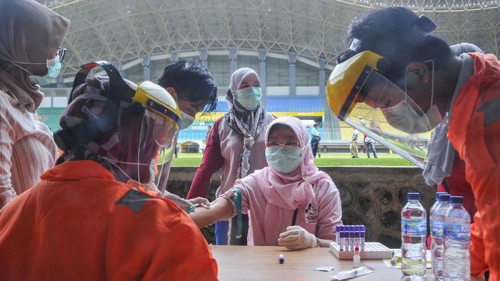 Petugas medis mengecek kesehatannya dengan mengambil sampel  darah dengan metode rapid test (pemeriksaan cepat) di Stadion Patriot Candrabhaga, Bekasi, Jawa Barat, Rabu (25/3/2020). Pemeriksaan yang dilakukan khusus tenaga medis di Bekasi guna memutus mata rantai penyebaran virus COVID-19. ANTARA FOTO/ Fakhri Hermansyah/hp.