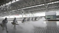 China juga telah membuka beberapa stasiun kereta api, termasuk di Provinsi Hubei. Petugas pemadam kebakaran pun menyemprotkan disenfektan untuk tindakan pengamanan. (Wang Shen/ Xinhua via AP)