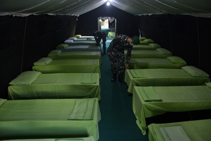 Anggota TNI menyiapkan fasilitas tempat tidur di dalam tenda posko siaga COVID-19 di halaman Rumah Sakit Pelamonia, Makassar, Sulawesi Selatan, Rabu (25/3/2020). Posko siaga COVID-19 tersebut menyiapkan ruang isolasi serta fasilitas pendukung dan tim medis oleh jajaran Kodam XIV Hasanuddin guna mengantisipasi serta mempercepat penanganan awal terhadap warga yang diduga terinfeksi COVID-19. ANTARA FOTO/Abriawan Abhe/aww.