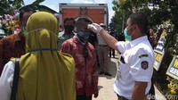 Para pelayat harus menjalani cek suhu tubung sebelum memasuki area pemakaman.