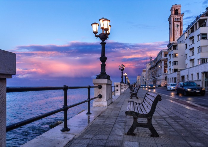 Bari seafront. Colorful amazing sunset. Coastline and city view. Twilight purple and blue sky.