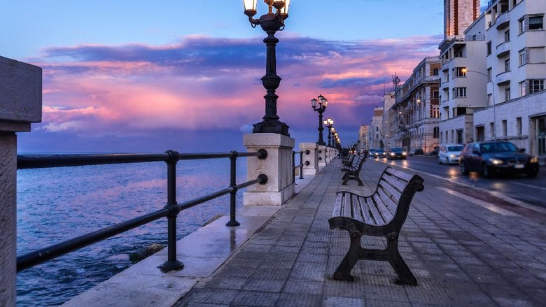 Bari seafront. Colorful amazing sunset. Coastline and city view. Twilight purple and blue sky.