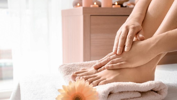 Young woman with beautiful pedicure and manicure after treatment in spa salon