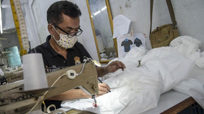 Pekerja membuat pakaian alat perlindungan diri (APD) tenaga medis di Pusat Industri Kecil, Penggilingan, Jakarta, Kamis (26/3/2020). Pakaian APD tersebut dijual Rp45.000 untuk jenis pakaian sekali pakai dan Rp75.000 untuk pakaian yang bisa dicuci. ANTARA FOTO/Galih Pradipta/ama.