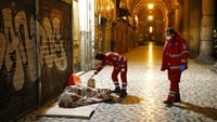 Sukarelawan Palang Merah membawa makanan serta cairan desifektan kepada para tuna wisma yang ada di jalanan kota Roma. Cecilia Fabiano/LaPresse via AP.