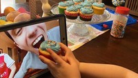 Terpisah jarak karena tak boleh keluar rumah, keluarga ini rayakan ulang tahun sang adik lewat sambungan video call lengkap dengan cupcake sebagai kue ulang tahun. Foto: Boredpanda