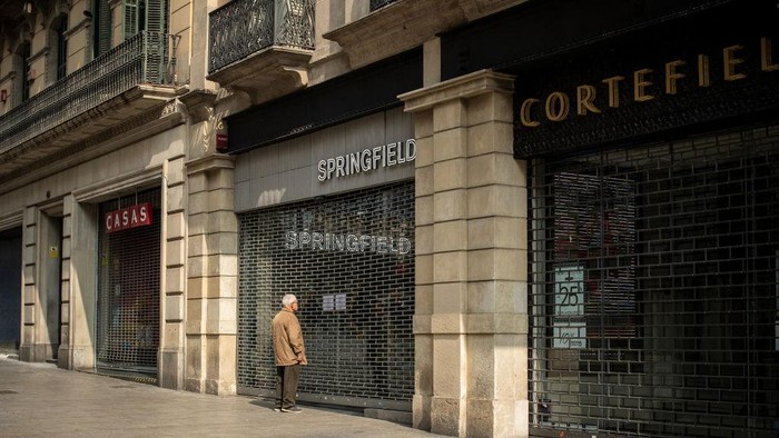 MILAN, ITALY - FEBRUARY 29: A man wears a protective mask as he walks in front of the Ermenegildo Zegna store in Via Montenapoleone, the most important road of the fashion district in the city center where all the luxury brand are located on February 29, 2020 in Milan, Italy. 
Italy registered a surge in coronavirus cases in the last few days with infections remaining centered on outbreaks in two northern regions, Lombardy and Veneto. But a few cases have turned up now in southern Italy too. In Italy so far 821 people have been infected and 21 have died, officials say, amid global efforts to stop the virus spreading. Italys Foreign Minister Luigi Di Maio told reporters that an infodemic of misleading news abroad was damaging Italys economy and reputation. Italys tourism association Assoturismo says March accommodation bookings are down by at least 200m (£170m; $219m) because of the virus. Schools, universities, cinemas and Milans famous La Scala opera house have been closed and several public events cancelled. Eleven towns at the centre of the outbreak - home to a total of 55,000 people - have been quarantined. There are fears that the outbreak may tip Italy into economic recession. (Photo by Marco Di Lauro/Getty Images)