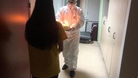 Selama menjalani masa karantina, wanita ini tetap merayakan ulang tahunnya dengan salah satu perawat yang menggunakan baju pelindung hazmat. Foto: Boredpanda