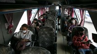 Orang-orang yang memakai masker duduk di bus pada 26 Maret 2020 di Bangkok, Thailand. Sekarang adalah satu kewajiban untuk mengenakan masker saat mengendarai angkutan umum dan bus yang hanya menjual 50% tiketnya guna menerapkan social distancing atau jarak sosial. Getty Images/Allison Joyce.