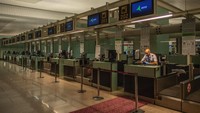 Seorang anggota staf Qatar Airways menunggu penumpang di meja check-in di terminal keberangkatan Bandara Barcelona yang hampir kosong di Barcelona, Spanyol. Pemerintah Spanyol akan memobilisasi 20 miliar euro tindakan krisis untuk membantu perusahaan dan pekerja. Sebagai bagian dari langkah-langkah melawan ekspansi virus. Getty Images/David Ramos.