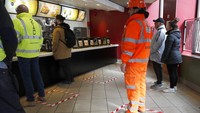 Orang-orang berdiri di tempat-tempat yang ditandai untuk menjaga jarak sosial di sebuah restoran cepat saji di London, Jumat, 20 Maret 2020. AP Photo/Frank Augstein.