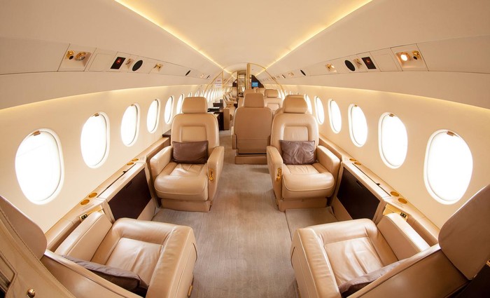 Corporate business jet setting on ramp with door open and sun setting in the background.