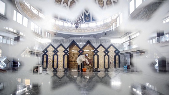 Pengurus masjid membersihkan Masjid Agung Baitul Faidzin pada waktu jam ibadah shalat Jumat di Cibinong, Bogor, Jawa Barat, Jumat (25/3/2020). Ketua Dewan Pertimbangan Majelis Ulama Indonesia (MUI) Din Syamsuddin mengimbau umat Muslim untuk sementara mengganti shalat Jumat dengan shalat zhuhur di rumah dalam kondisi darurat seperti sekarang ini, hal itu lantaran masih merebaknyavirus corona (COVID-19) di Indonesia. ANTARA FOTO/Yulius Satria Wijaya/foc.