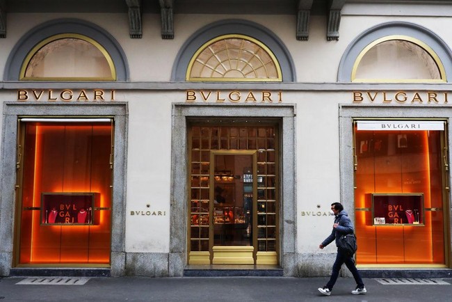 Seorang pria melintas di depan butik Bulgari di Italia, dengan menggunakan masker. Italia termasuk negara yang warganya banyak menjadi korban virus corona. Italia menjadi negara dengan jumlah kematian tertinggi mencapai 8.215 jiwa. Foto: Getty Images