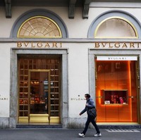 Seorang pria melintas di depan butik Bulgari di Italia, dengan menggunakan masker. Italia termasuk negara yang warganya banyak menjadi korban virus corona. Italia menjadi negara dengan jumlah kematian tertinggi mencapai 8.215 jiwa. Foto: Getty Images