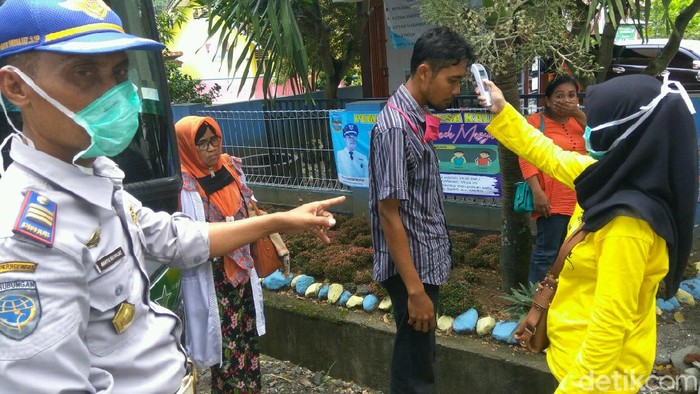 Petugas memeriksa kesehatan penumpang bus di Pangandaran