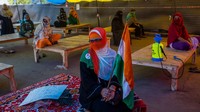 Para pengunjuk rasa tertutup dengan baik duduk di jarak sekitar satu meter ketika mereka melanjutkan protes mereka terhadap undang-undang kewarganegaraan baru di tengah perintah penutupan oleh pemerintah Delhi sebagai langkah pencegahan terhadap COVID-19 pada 23 Maret 2020 di daerah Shaheen Bagh di Delhi, India. Getty Images/Yawar Nazir.