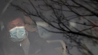 Dengan memakai masker, sopir bus mengantarkan wisatawan Jerman ke Bandara Kathmandu.