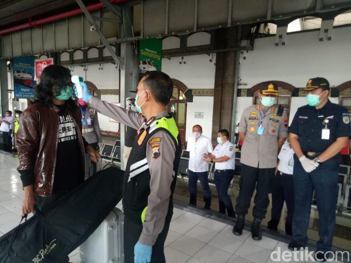 Polisi memeriksa pemudik yang baru tiba di Stasiun Tawang, Semarang, Sabtu (28/3/2020).