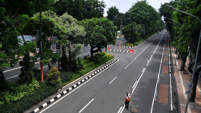 Polisi berjaga di Jalan Darmo yang ditutup, di Surabaya, Jawa Timur, Sabtu (28/3/2020). Penutupan sejumlah jalan di Surabaya tersebut agar terbebas dari segala aktivitas warga dan kendaraan guna mencegah penyebaran Virus Corona (COVID-19). ANTARA FOTO/Zabur Karuru/ama.