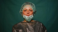 Tak hanya perawat dan dokter, para pekerja administrasi rumah sakit juga ikut andil dalam memerangi pandemi Corona. Dalam fotoa ada Laura Orsini, 39, yang masih mengenakan APD di akhir shiftnya di Roma. AP Photo/Domenico Stinellis.