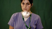 Salah satu perawat bernama Lucia  Perolari, 24, berpose di depan kamera, usai melepas APD dari tubuhnya. AP Photo/Antonio Calanni.