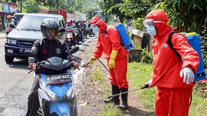 PENYEKATAN DAN PEMBATASAN KENDARAAN DI BLITAR Petugas BPBD menyemprotkan cairan disinfektan pada sejumlah kendaraan di Jalan Lintas Blitar-Malang di Blitar, Jawa Timur, Sabtu (28/3/2020). Selain melakukan penyekatan dan pembatasan kendaraan yang hendak keluar-masuk, Petugas Gabungan dari Gugus Tugas Percepatan Penanganan Virus Corona (COVID-19) Kabupaten Blitar juga melarang sejumlah kendaraan dari daerah lain yang tidak memiliki kepentingan untuk memasuki kawasan Blitar, Guna menekan penyebaran COVID-19. ANTARA FOTO/Irfan Anshori/ama.