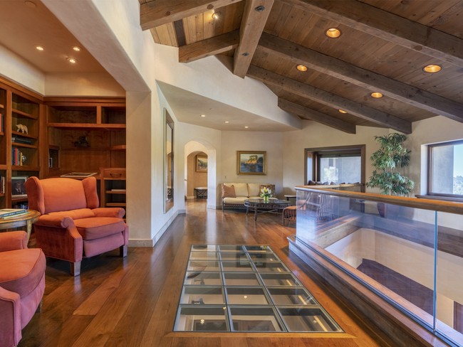 Terdiri dari 20 ruangan, rumah ini hadir dengan interior bergaya rustic modern. Tampak lantai kayu di area atas dikombinasikan dengan lantai kaca yang transparan. (Foto: Dok. REX Real Estate via Business Insider)