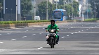 Pengendara motor melintasi Jalan Jenderal Sudirman yang tampak sepi.