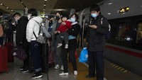 Sejumlah penumpang turun dari kereta usai tiba di stasiun kereta usai melakukan perjalanan dari Beijing menuju Wuhan, Provinsi Hubei, China, Minggu (29/3/2020).