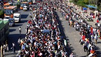 Ratusan pekerja migran bersama keluarga mereka berkumpul di kawasan New Delhi, Sabtu (28/3). Mereka berkumpul untuk menaiki sejumlah bus untuk pulang ke kampung halaman. AP Photo.