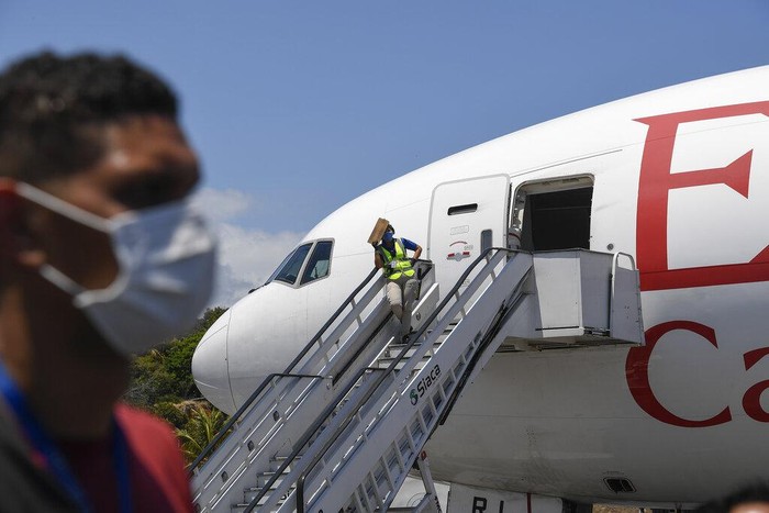 Seorang petugas menurunkan berbagai kardus yang berisi alat medis dari pesawat di Bandara Maiquetia yang berada di kawasan La Guaira, Venezuela, Sabtu (28/3/2020) waktu setempat.