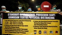 Plt Walikota Blitar Santoso (ketiga kiri) didampingi Dandim 0808/Blitar Letkol Inf Krisbianto (kedua kiri) dan Kapolres Blitar Kota AKBP Leonard Sinambela memasang spanduk kawasan tertib Pembatasan Sosial (Physical Distancing) di salah satu kawasan permukiman di Blitar, Jawa Timur, Sabtu (28/3/2020) malam. Selain mulai menerapkan kawasan Physical Distancing, Pemda setempat juga melakukan penutupan sejumlah jalan protokoler guna mencegah penyebaran COVID-19 di daerah itu.  