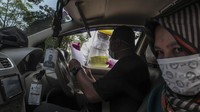 Petugas Dinas Kesehatan Kota Depok melakukan pengecekan kepada pengguna kendaraan saat tes cepat (rapid test) COVID-19 dengan sistem drive thru di Cimanggis, Depok, Jawa Barat, Minggu (29/3/2020).