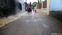 Warga saat menggelar operasi disinfeksi Corona di kawasan Cipedak, Srengseng Sawah, Jagakarsa, Jakarta Selatan, Minggu (29/3/2020).
