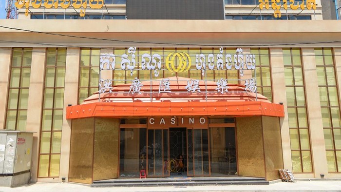 A man sits inside a casino in Sihanoukville on February 18, 2020. (Photo by TANG CHHIN Sothy / AFP)