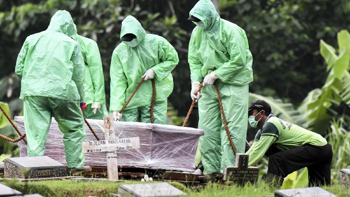 KORBAN MENINGGAL AKIBAT COVID-19 TERUS BERTAMBAH Petugas pemakaman menurunkan peti jenazah pasien COVID-19 di TPU Pondok Ranggon, Jakarta, Senin (30/3/2020). Juru bicara pemerintah untuk penanganan COVID-19 Achmad Yurianto per Senin (30/3/2020) pukul 12.00 WIB menyatakan jumlah pasien positif COVID-19 di Indonesia telah mencapai 1.414 kasus, pasien yang telah dinyatakan sembuh sebanyak 75 orang, sementara kasus kematian bertambah delapan orang dari sebelumnya 114 orang menjadi 122 orang. ANTARA FOTO/Muhammad Adimaja/foc.