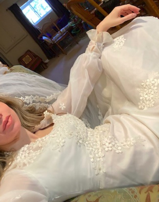 Merasa terinspirasi, ibu lainnya juga membagikan foto dirinya sedang duduk santai di rumah sambil mengenakan gaun pengantin lengkap dengan veil. Selain dapat menghilangkan rasa bosan di rumah, hal ini juga bisa membuat kembali bernostalgia ke masa lalu. Foto: Twitter@DianacBiggs